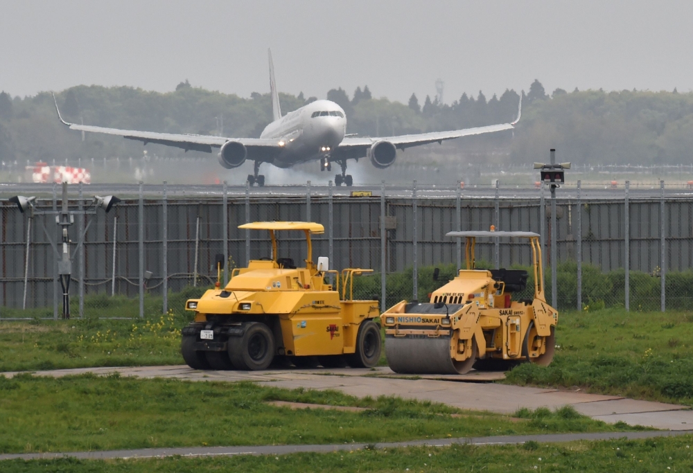 This picture taken on April 12, 2018 shows an airplane landing on a runway of the expanding Narita airport, Tokyo's main international gateway, in Chiba prefecture. — AFP