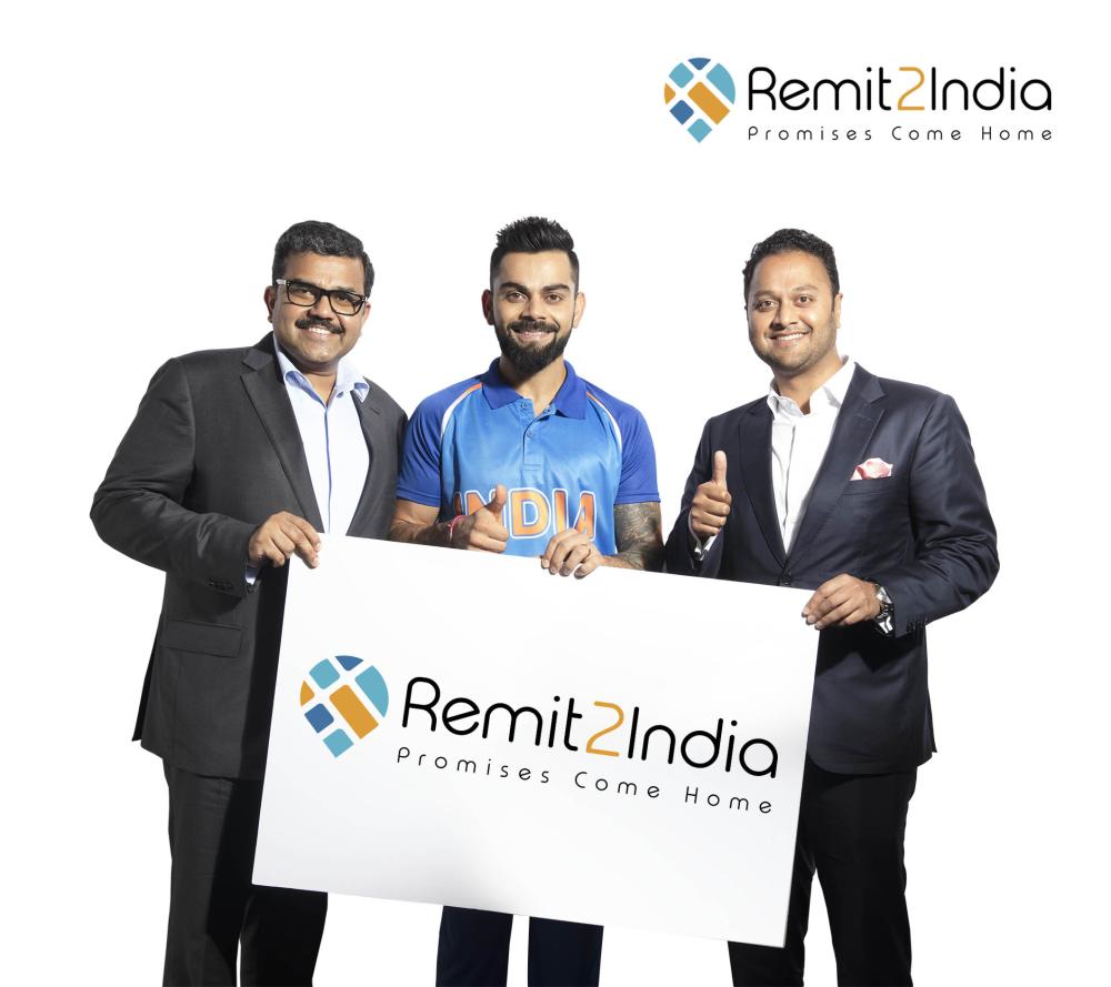 Indian Cricket Captain Virat Kohli with Finablr Executive Director Binay Shetty (right) and Finablr Executive Director Promoth Manghat (left). — Courtesy photo