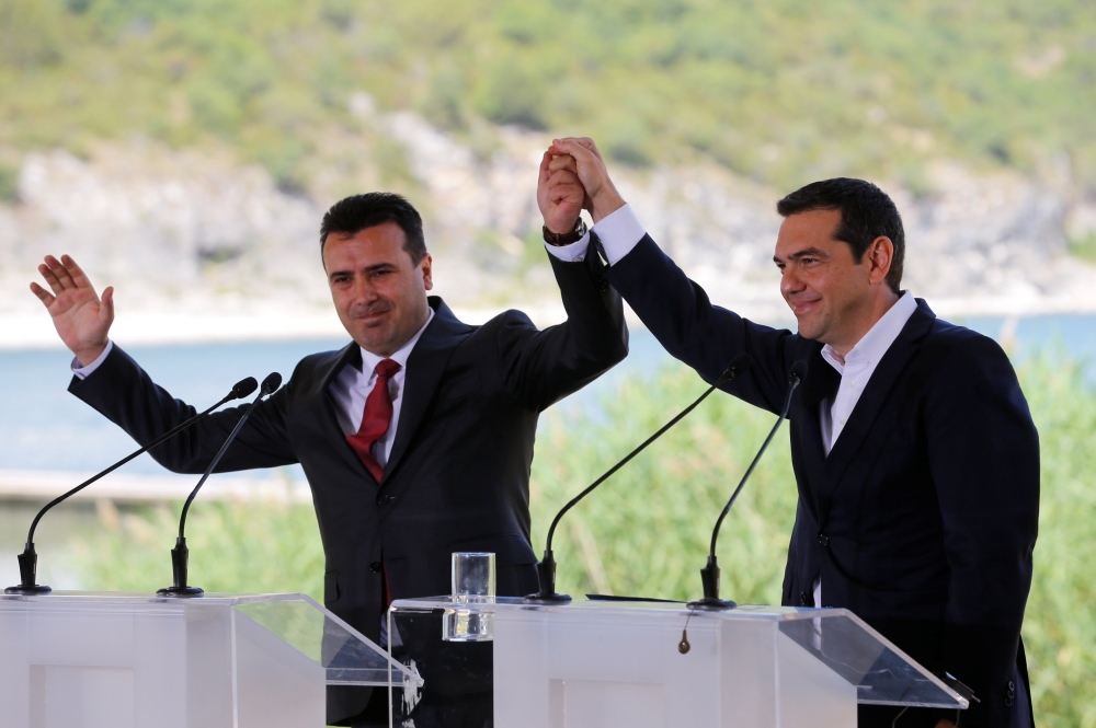 Greek Prime Minister Alexis Tsipras and Macedonian Prime Minister Zoran Zaev gesture before the signing of an accord to settle a long dispute over the former Yugoslav republic’s name in the village of Psarades, in Prespes, Greece, on Sunday. — Reuters