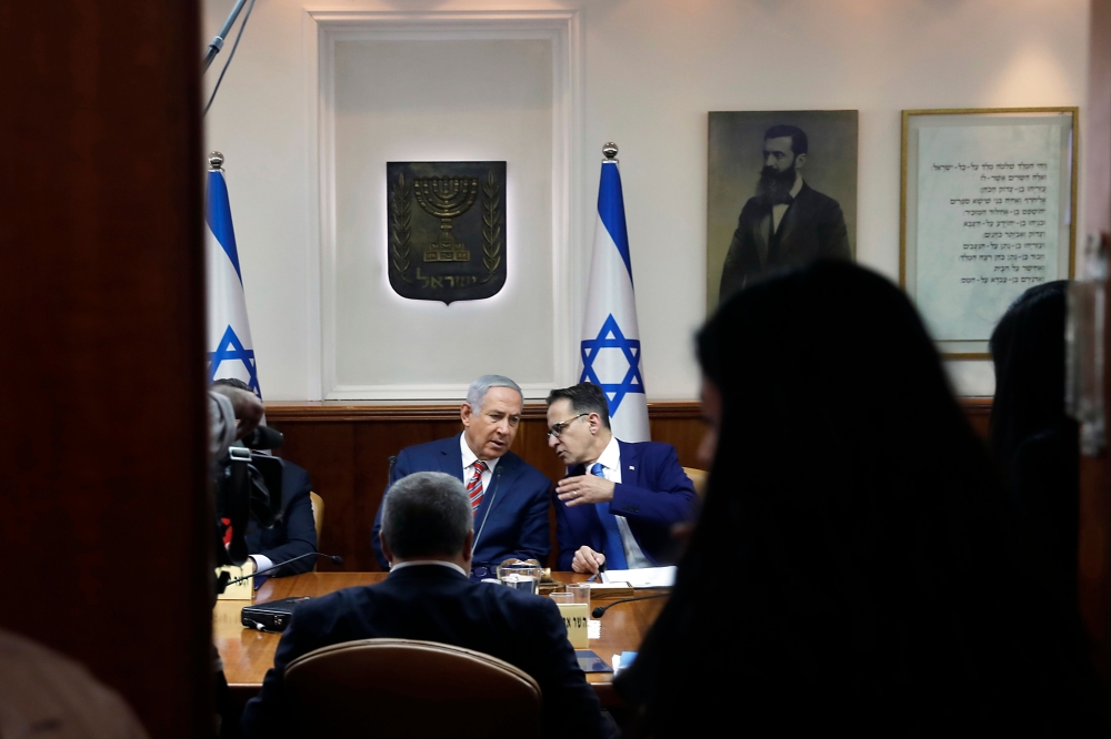 Israeli Prime Minister Benjamin Netanyahu, left, listens to Israeli Cabinet Secretary Tzachi Braverman during the weekly Cabinet meeting at the prime minister’s office in Jerusalem on Sunday. — AFP