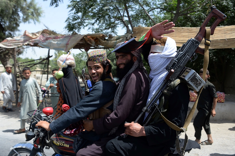 Afghan Taliban militants ride a motorbike as they take to the streets to celebrate a ceasefire on the second day of Eid in the outskirts of Jalalabad in this June 16, 2018 file photo. — AFP