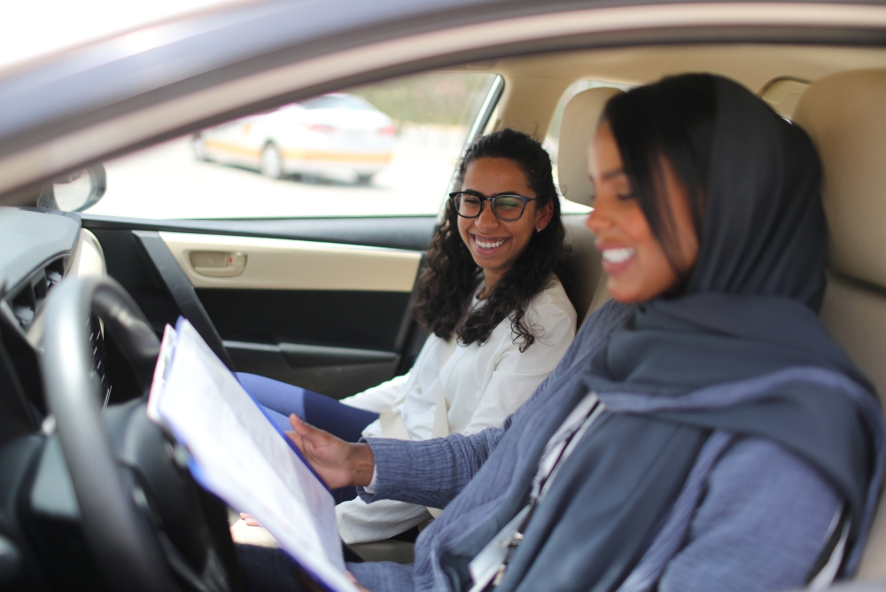Driving instructor Ahlam Al-Somali (R) reads instructions before getting ready to drive with trainee Maria Al-Faraj at Saudi Aramco Driving Center in Dhahran. — Reuters