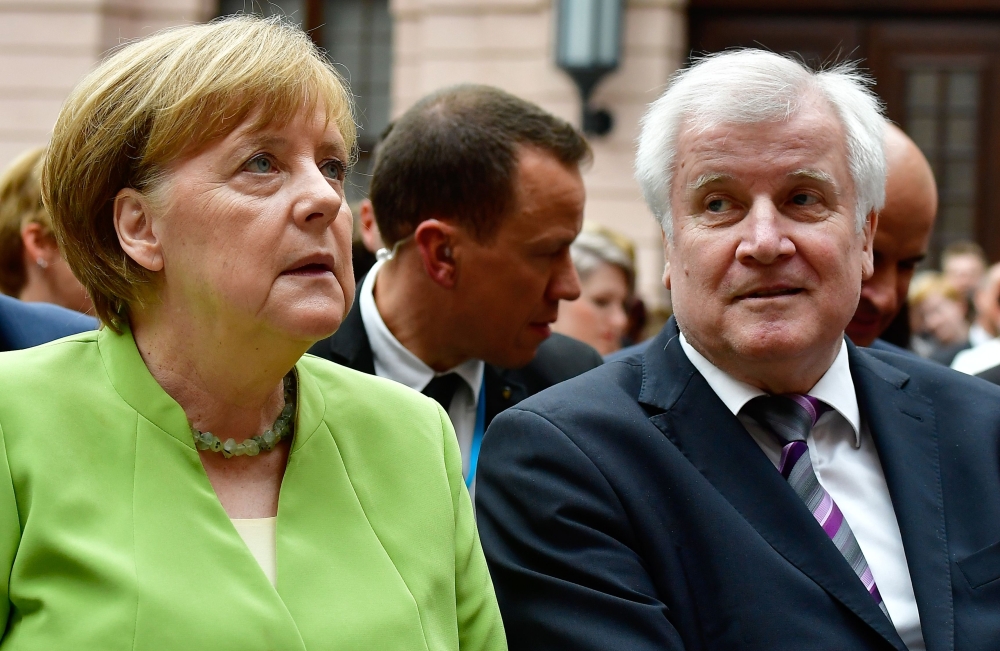 German Chancellor Angela Merkel and German Interior Minister Horst Seehofer attend an event on the occasion of the World Refugee Day at the German Historical Museum in Berlin on Wednesday. — AFP