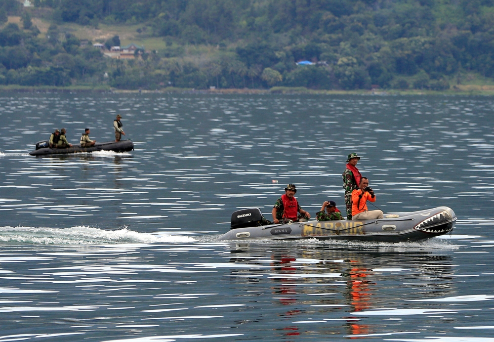Rescue team members using rubber boats to find missing passengers from a ferry accident at the Lake Toba, in Simalungun, North Sumatra, Indonesia, on Wednesday. — Reuters