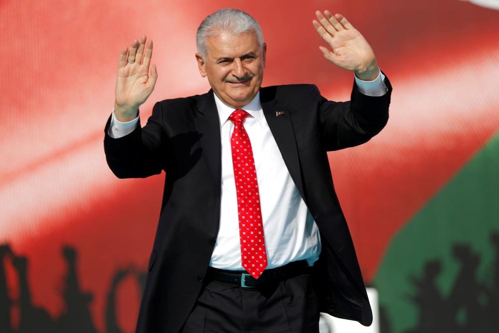 Turkish Prime Minister Binali Yildirim greets the crowd as he takes part in a protest in Istanbul, last month. — Reuters