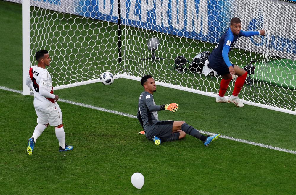 France's Kylian Mbappe (R) looks back after scoring as Peru's goalkeeper Pedro Gallese and Miguel Trauco react  during their World Cup match at Ekaterinburg Arena, Yekaterinburg, Russia, Thursday. — Reuters