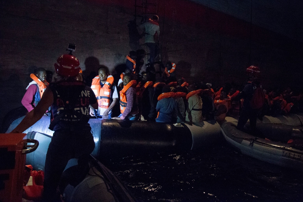 Migrants board a container ship of Danish shipping company Maersk Line after they were rescued from a shipwrecked vessel at sea on Friday. — AFP