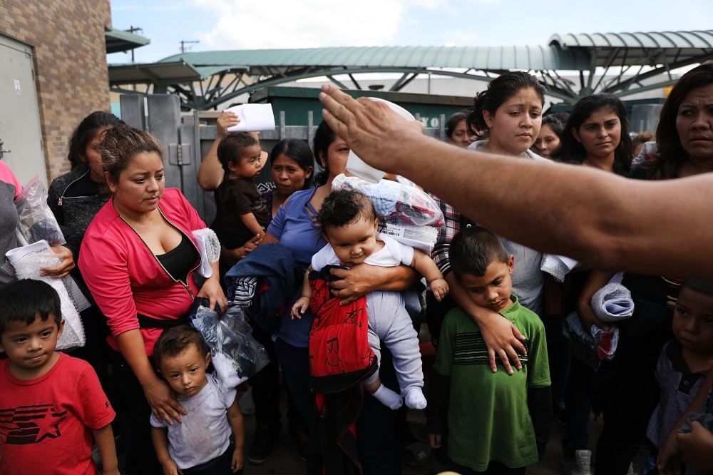 Dozens of women and their children, many fleeing poverty and violence in Honduras, Guatamala and El Salvador, arrive at a bus station following release from Customs and Border Protection in McAllen, Texas, on Friday. — AFP