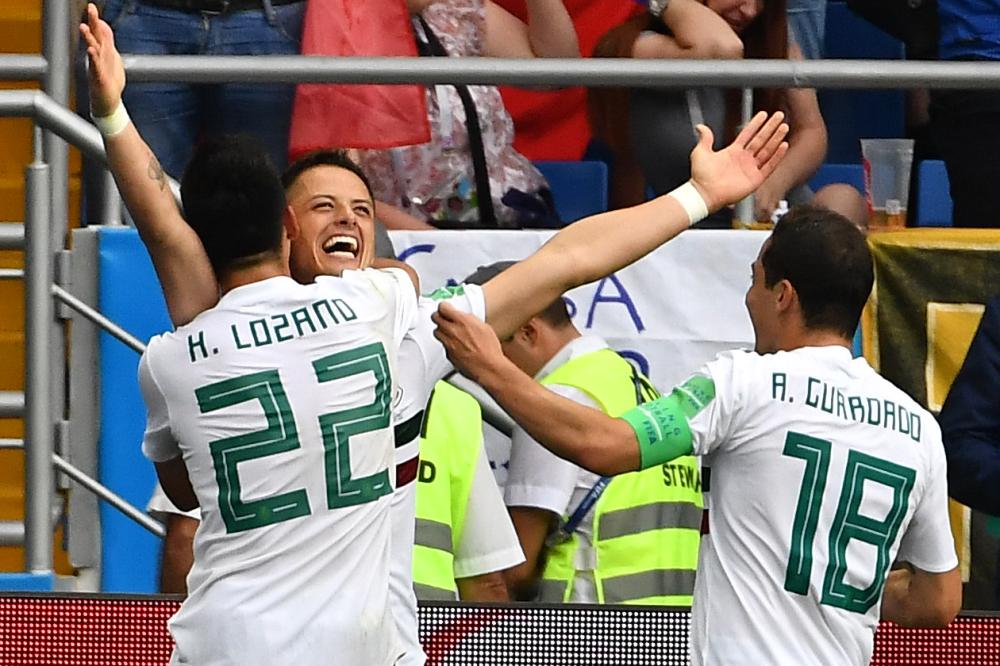 Mexico's forward Javier Hernandez celebrates with teamates Hirving Lozano (L) and Andres Guardado after scoring during the Russia 2018 World Cup Group F football match against South Korea at the Rostov Arena in Rostov-On-Don Saturday. — AFP