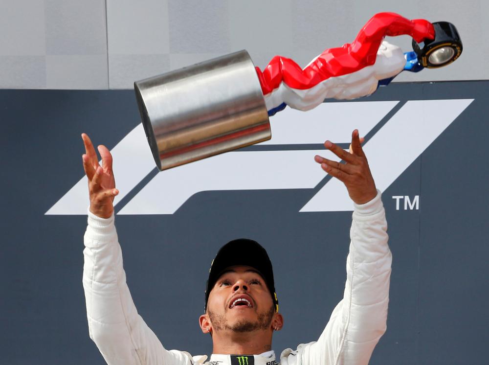 Mercedes’ Lewis Hamilton celebrates with the trophy on the podium after winning the race at the French Grand Prix in Le Castellet, France, Sunday. — Reuters
