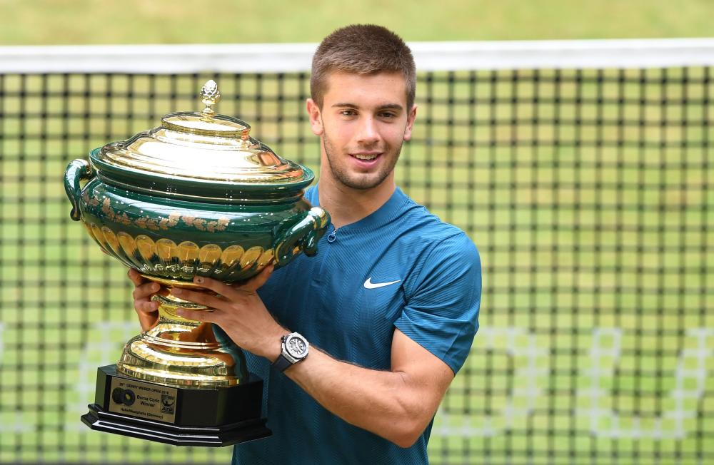 Borna Coric from Croatia poses with his trophy after defeating Roger Federer of Switzerland in their final match at the ATP Tennis Tournament in Halle, western Germany, Sunday. — AFP