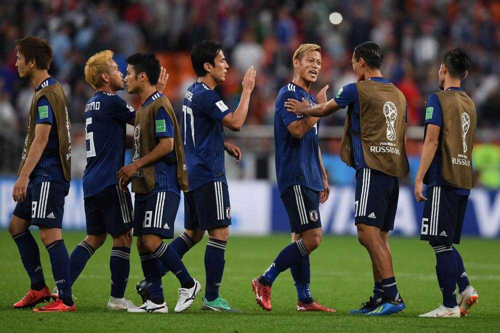 Japan's players celebrate at the end of their World Cup match against Senegal at the Ekaterinburg Arena in Ekaterinburg Sunday. — AFP 