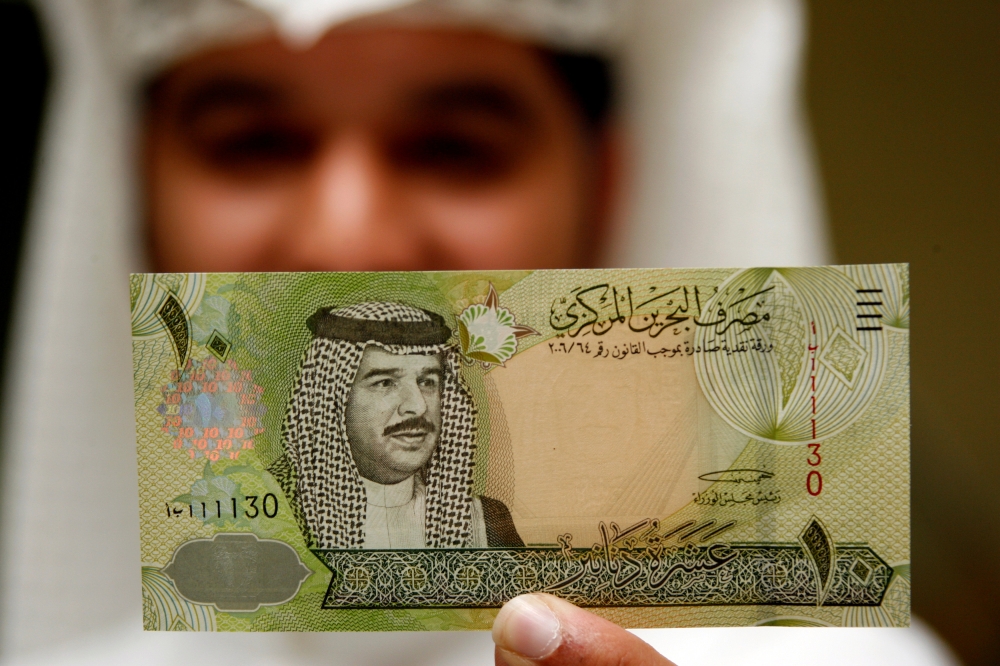 A Central Bank of Bahrain official shows a new BD$10 (Bahraini 10 Dinars Note) on the first day of its release in Manama in this March 17, 2008, file photo. — AFP