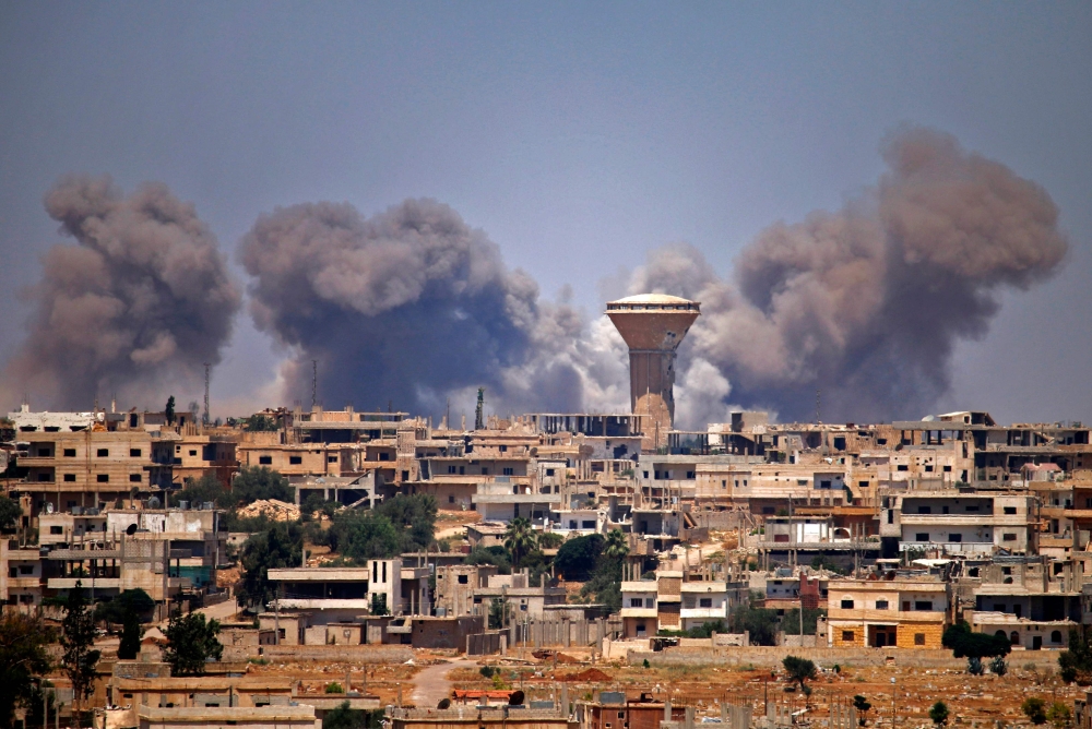 Smoke rises above rebel-held areas of the city of Daraa during reported air strikes by Syrian regime forces on Thursday. — AFP