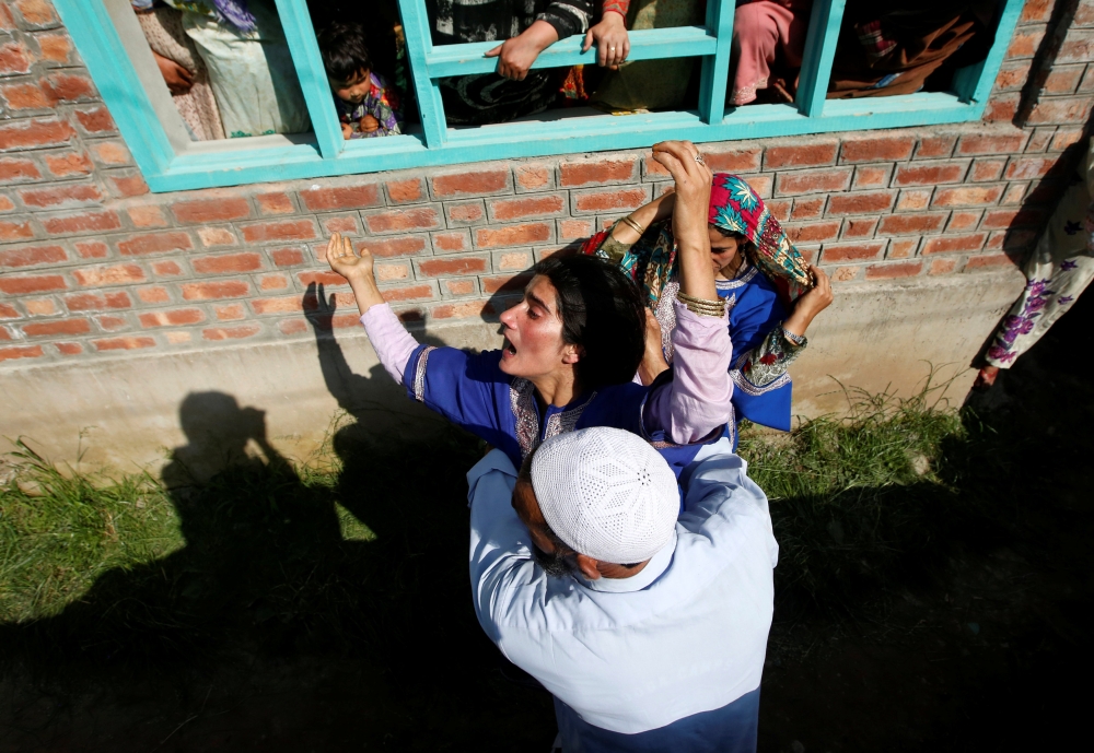 A man tries to console a woman as she watches the body of Tamsheel Ahmad Khan, a civilian who according to local media died during clashes between protesters and Indian security forces, during his funeral at Vehil village in Shopian district, Kashmir, on Tuesday. — Reuters