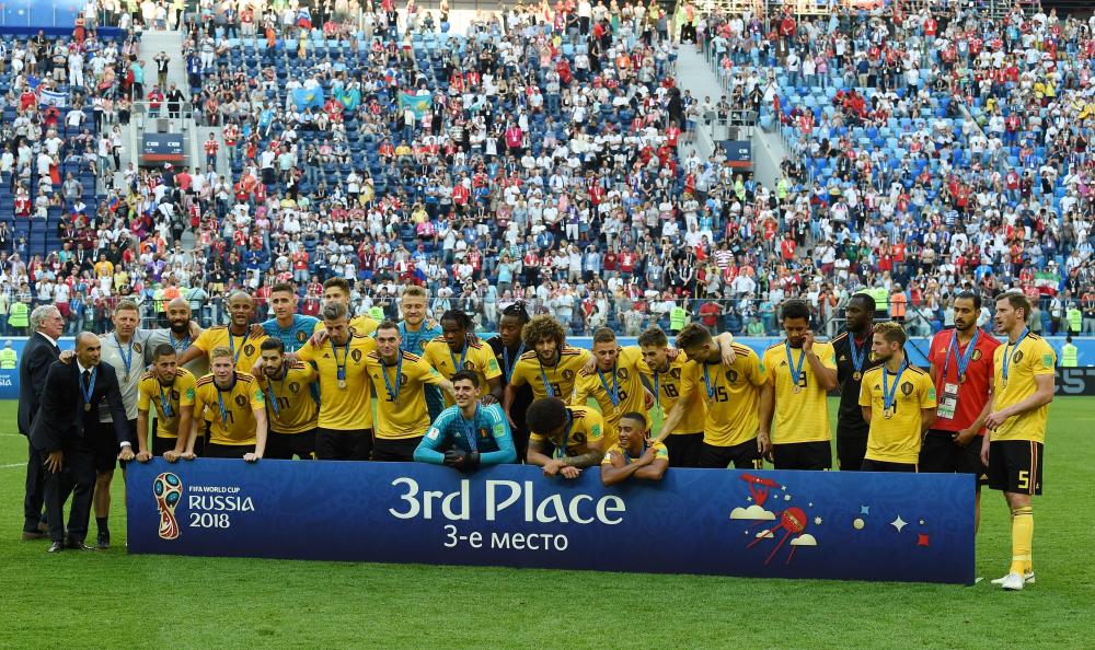 Belgium players and officials pose with their medals after winning the third place at the 2018 World Cup by beating England at the Saint Petersburg Stadium Saturday. —  AFP

