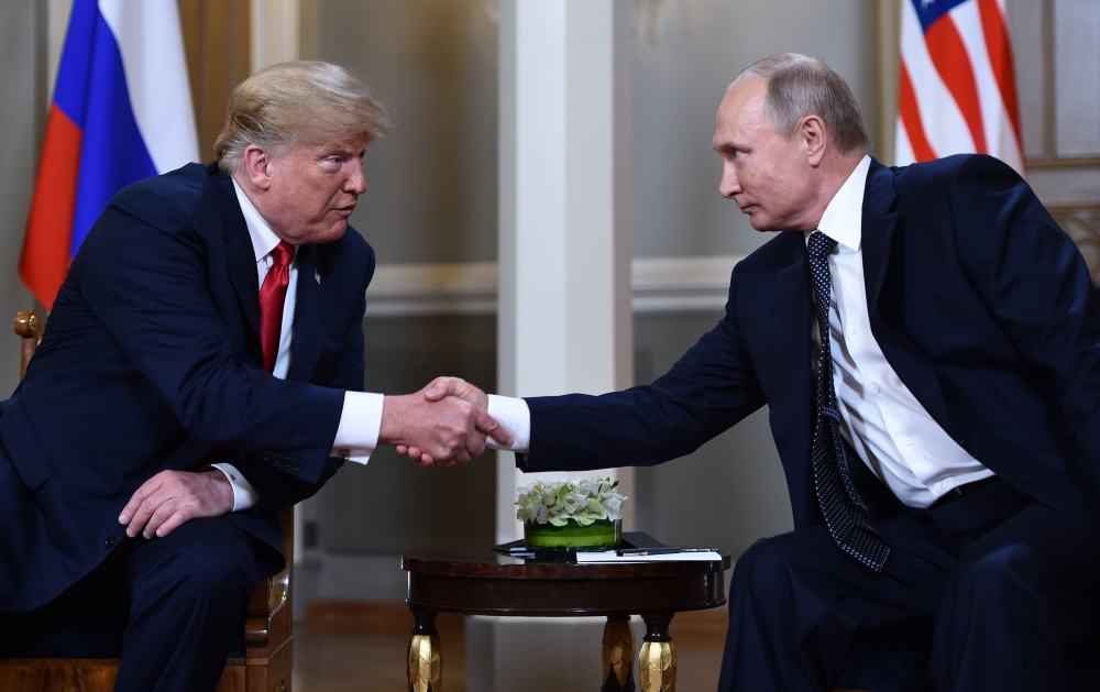 Russian President Vladimir Putin, right, and US President Donald Trump shake hands before a meeting in Helsinki on Monday. — AFP