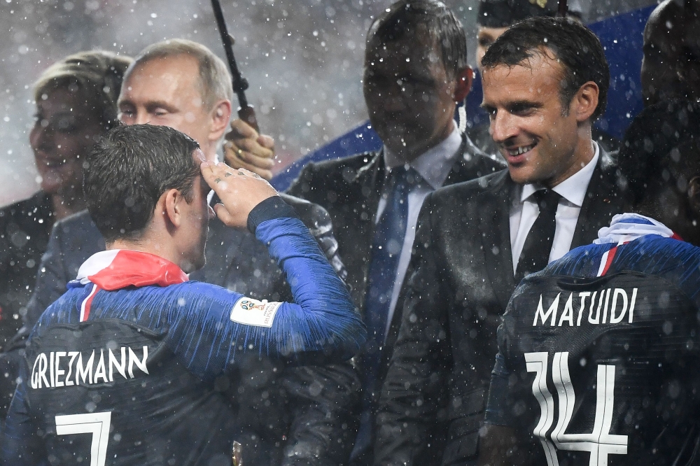 French President Emmanuel Macron (R) congratulates France's coach Didier Deschamps during the trophy ceremony at the end of the Russia 2018 World Cup final football match between France and Croatia at the Luzhniki Stadium in Moscow on Sunday. — AFP