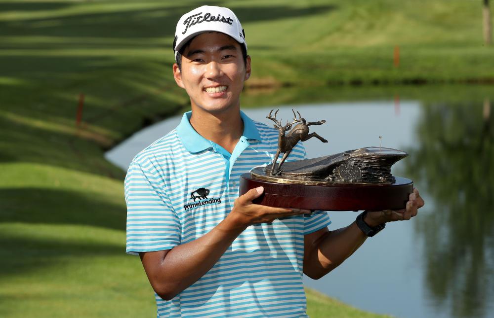 Michael Kim celebrates with the trophy after winning the John Deere Classic at TPC Deere Run in Silvis, Illinois, Sunday. — AFP 
