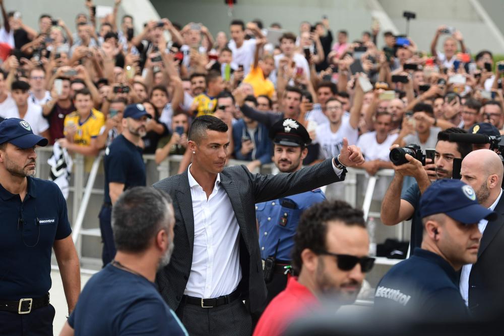 Cristiano Ronaldo gestures as he arrives at the Juventus medical center at the Alliance Stadium in Turin Monday. Ronaldo arrived in Turin ahead of his official unveiling as Juventus’ superstar summer signing Tuesday. — AFP 