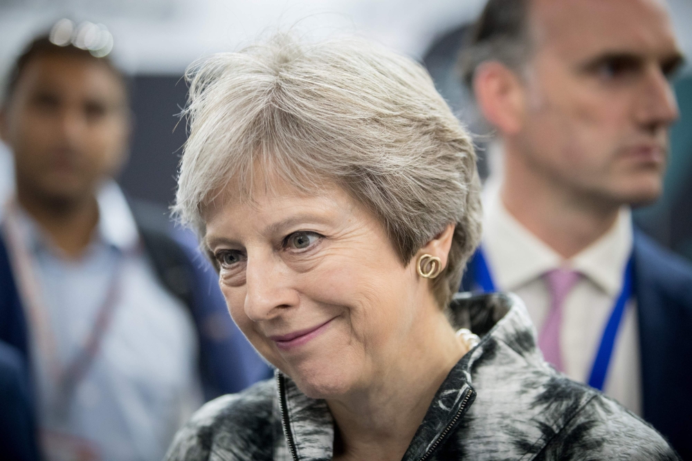 Britain’s Prime Minister Theresa May speaks with guests as she opens the Farnborough Airshow, south west of London, on Monday. — AFP 