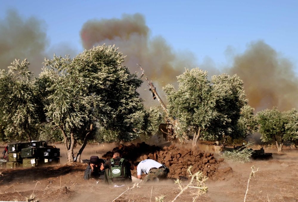 Syrian rebels fire rockets and artillery shells during clashes with regime forces advancing toward the town of Al-Hara in the southern Syrian Daraa province, Monday. — AFP