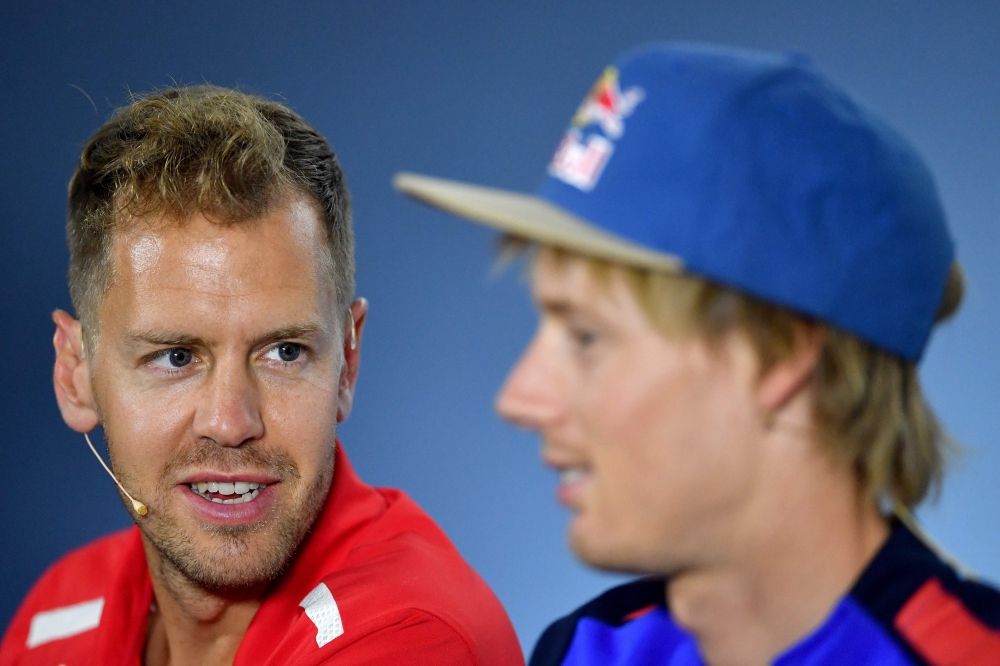 Ferrari's German driver Sebastian Vettel talks to Toro Rosso's New Zealand's driver Brendon Hartley (R) during a press conference of drivers ahead of the German Formula One Grand Prix at the Hockenheimring racing circuit on Thursday in Hockenheim, southern Germany. — AFP