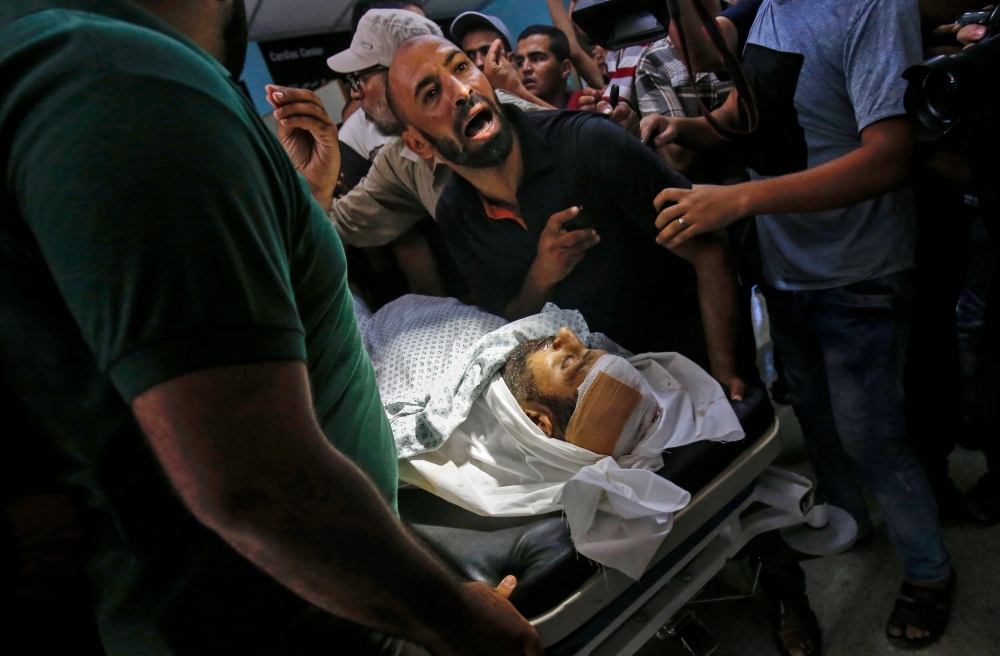 Relatives mourn over the body of Abdel Karim Radwan, who was killed in an Israeli air strike earlier today, at a hospital in Khan Yunis in the southern Gaza Strip on Thursday. — AFP