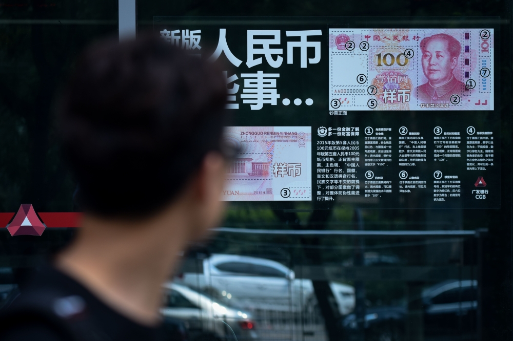This file photo shows Chinese 100 yuan notes in Beijing. The Chinese currency continued its sharp decline on Friday despite US President Donald Trump's bid to rein in the dollar, as analysts pointed out that a weaker yuan aids Beijing in its trade tussle with Washington. — AFP