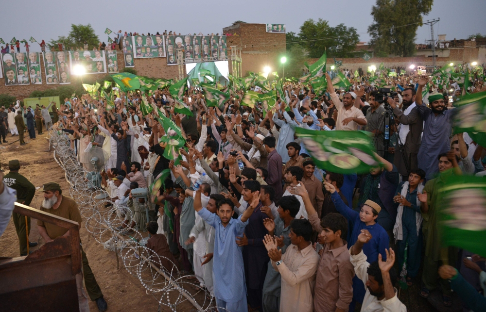 Supporters of Shabaz Sharif, the younger brother of ousted Pakistani Prime Minister Nawaz Sharif and the head of Pakistan Muslim League-Nawaz (PML-N), wave the party’s flag as they attend his campaign rally in Pindi Gheb, in the district of Attock, in the Punjab province, on Thursday. — AFP