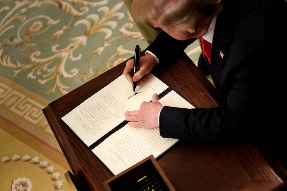 US President Donald Trump signs an executive order during an jobs creation pledge event in the East Room of the White House Thursday in Washington, DC.  — AFP