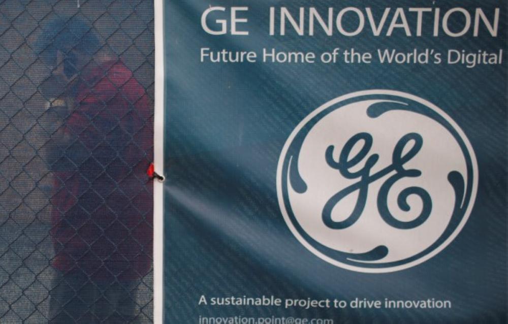 File photo shows a man walking past the GE banner.