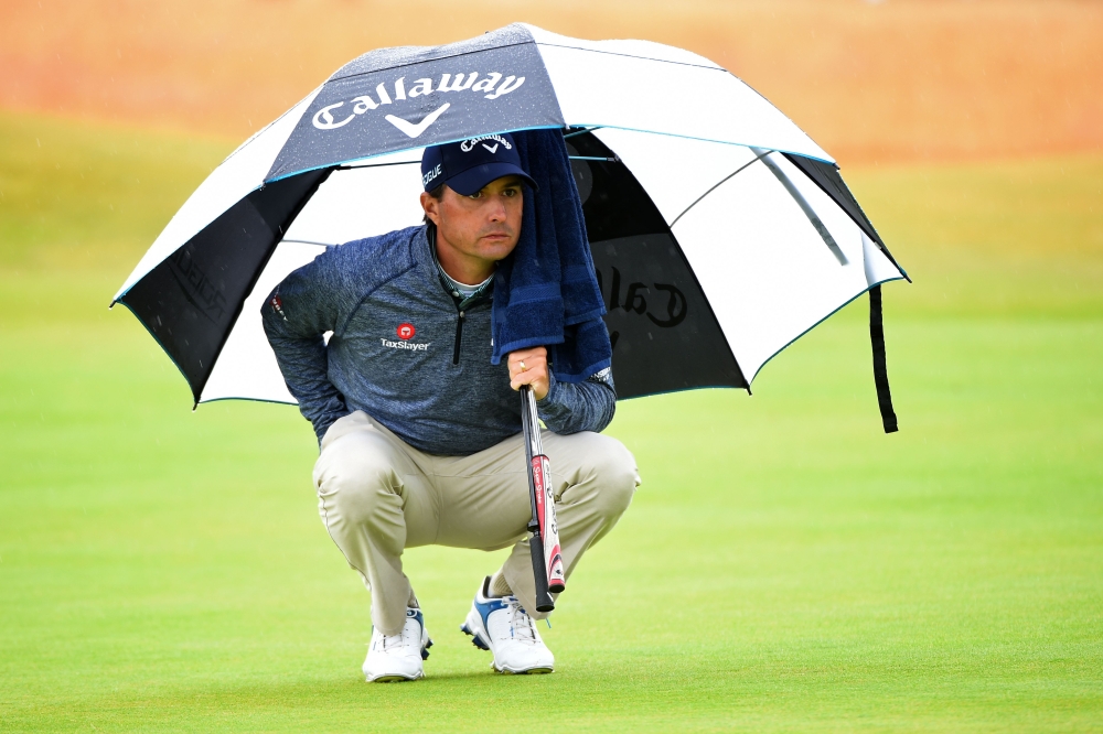 US golfer Kevin Kisner shelters from the rain on the 5th green during his second round on day 2 of The 147th Open golf Championship at Carnoustie, Scotland on Friday. — AFP