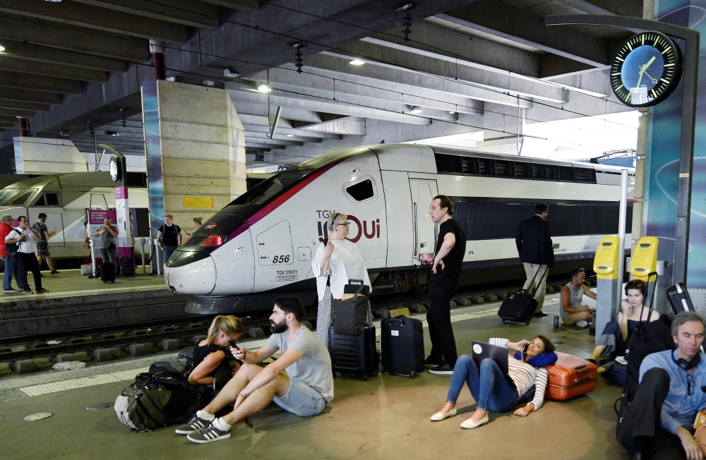 People wait on a platform of the Montparnasse railway station in Paris after several trains have been delayed following a fire of an electric transformer in the nearby city of Issy-les-Moulineaux on Friday. — AFP