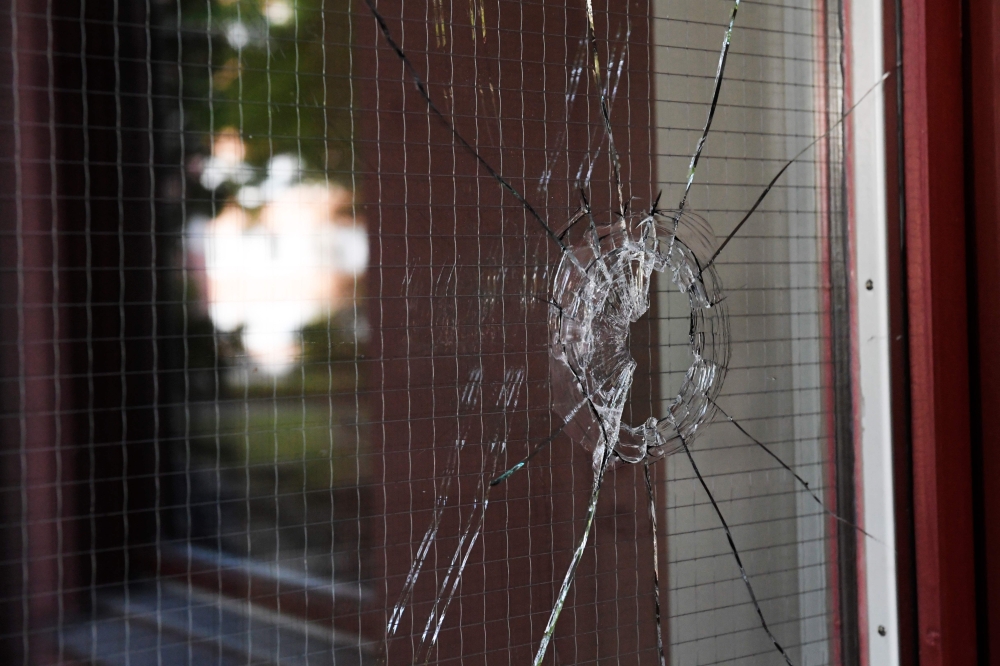 A hole in a glass door is seen at the site where 20-year-old autistic man with Down Syndrome holding a toy gun was shot by police in Stockholm on Friday. — AFP