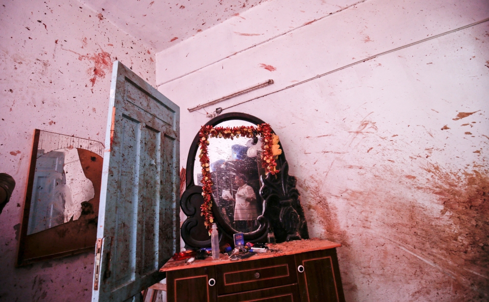 A relative of 23-year-old Palestinian Enas Khammash, who was killed with her toddler in an Israeli airstrike, inspects their bedroom in Deir Al-Balah in the central Gaza Strip on Thursday. — AFP