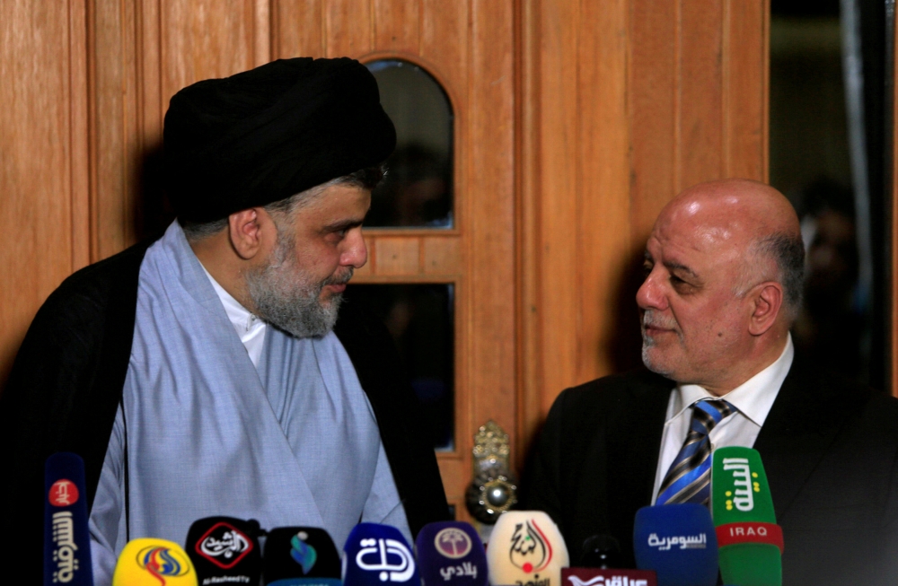 Iraqi Shiite cleric Moqtada Al-Sadr speaks to Iraqi Prime Minister Haider Al-Abadi during a news conference in Najaf, Iraq, in this June 23, 2018 file photo. — Reuters