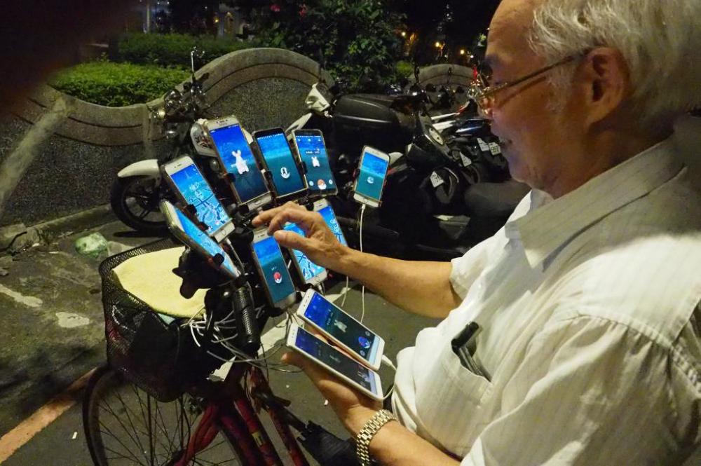 Chen San-yuan, a 69-year-old Feng Shui Master, uses 11 cellphones to play 'Pokemon Go' in a park in New Taipei City, Taiwan, on Sunday. - EPA