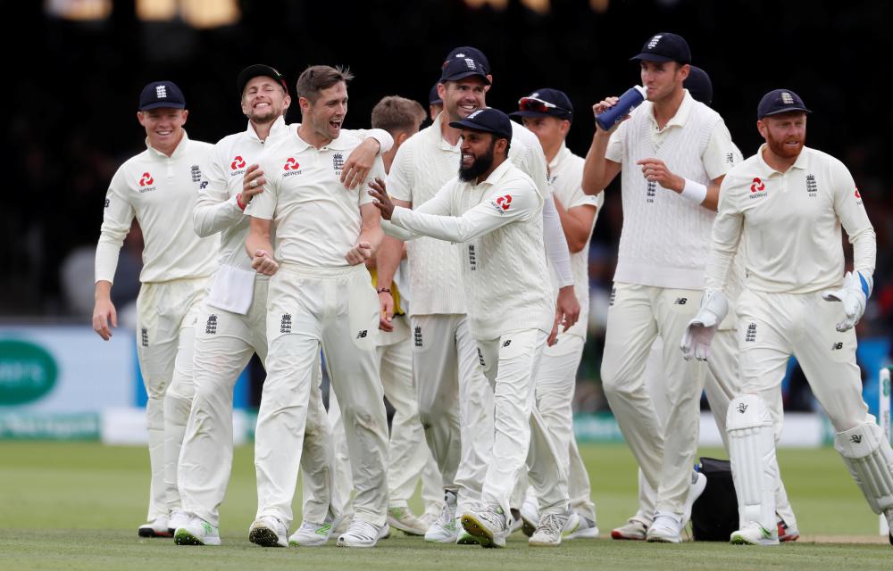 England's Chris Woakes celebrates with teammates after beating India in the second cricket Test at Lord’s Sunday. — Reuters