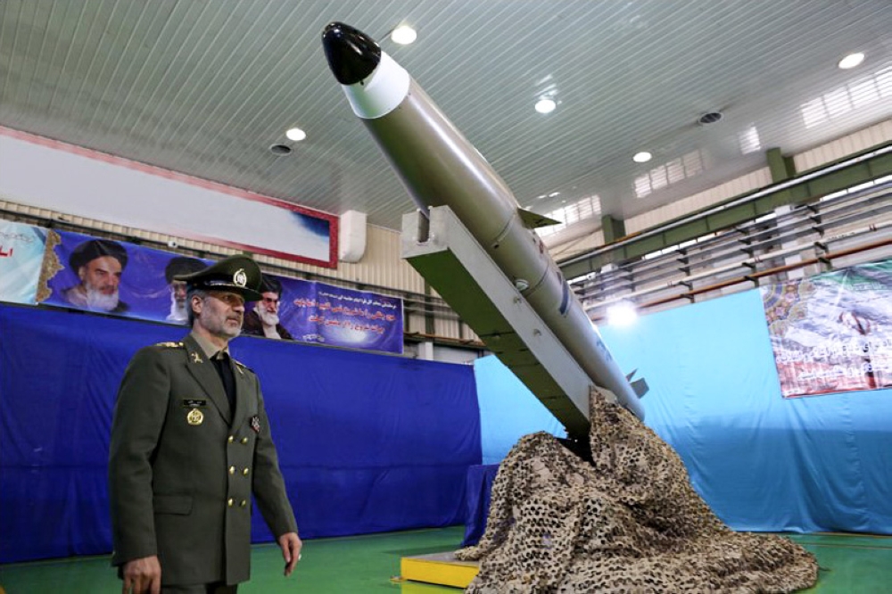 Iran's Defense Minister Brig. Gen. Amir Hatami stands by the next generation short-range ballistic missile 