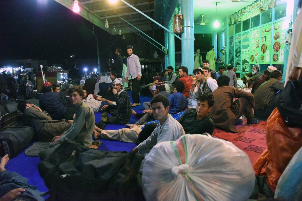 Afghan passengers bound to Kabul wait at a bus station in Kandahar province as the Kabul-Kandahar bus services stopped following a Taliban assault in the city of Ghazni on Monday. — AFP