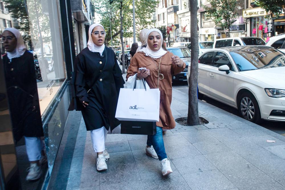 
Veiled women hold shopping bags, as they walk in Istanbul. — AFP