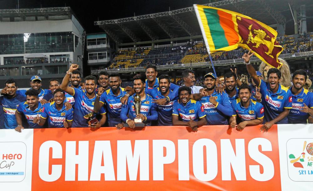 Sri Lanka cricket team members pose for photographs with the trophy after they won the T20 match against South Africa in Colombo Tuesday. — Reuters 