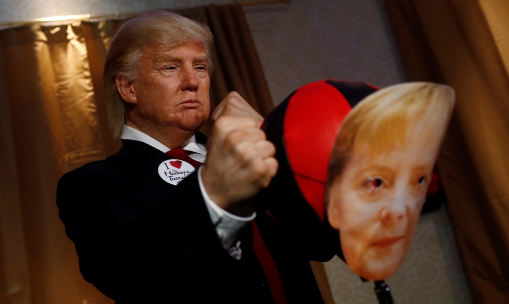 A performer wearing a mask of US President Donald Trump hits a punching ball with a mask of German Chancellor Angela Merkel in the Madame Tussauds wax museum in Berlin, Germany on Wednesday. - Reuters