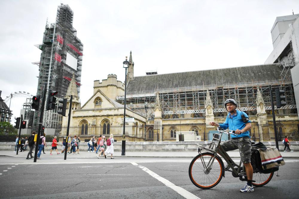 A cyclist waits at traffic lights outside the Houses of Parliament in central London on Wednesday close to the scene of a suspected terror attack on Tuesday. — AFP