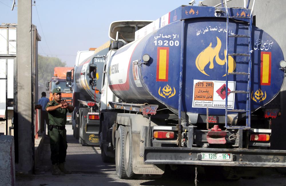 A member of Palestinian security forces gestures as a fuel tanker arrives at Kerem Shalom crossing in Rafah in the southern Gaza Strip on Wednesday. — Reuters