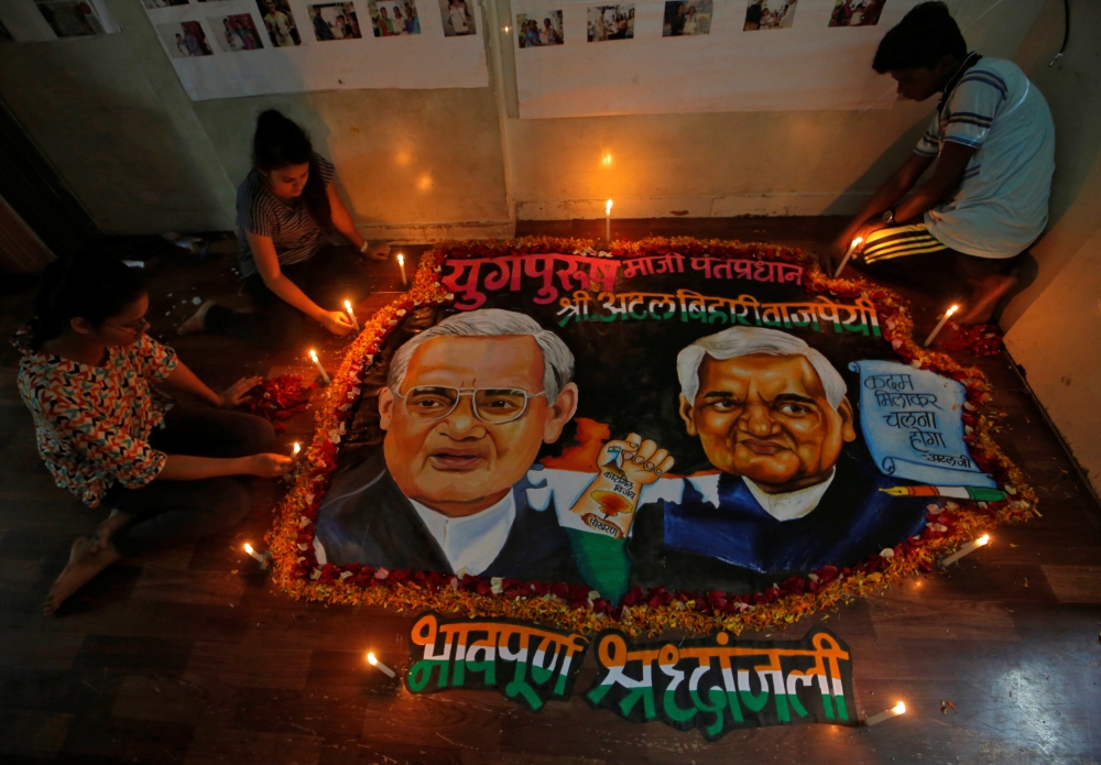 Students place candles around a painting featuring India’s former Prime Minister Atal Bihari Vajpayee to pay him homage in Mumbai, India, on Thursday. — Reuters