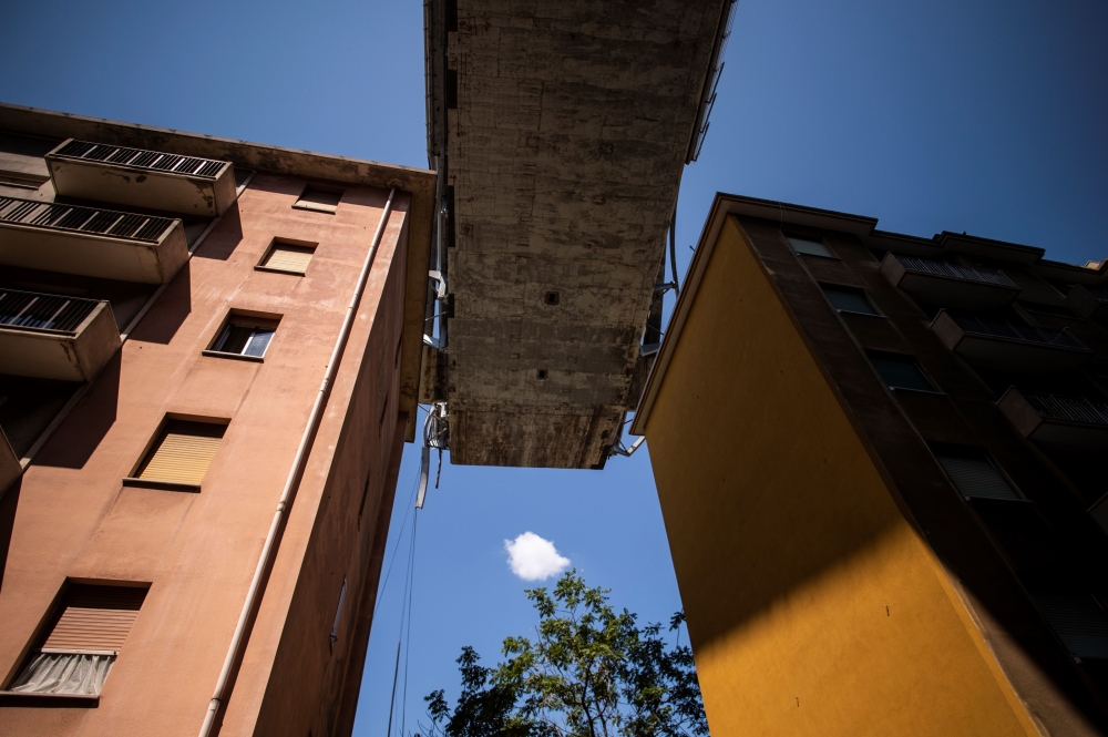 Appartment buildings are seen under the Morandi motorway bridge, two days after a section collapsed in Genoa on Thursday. — AFP