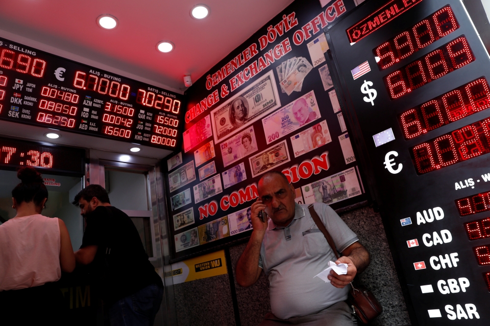 People change money at a currency exchange office in Istanbul on Friday. — Reuters