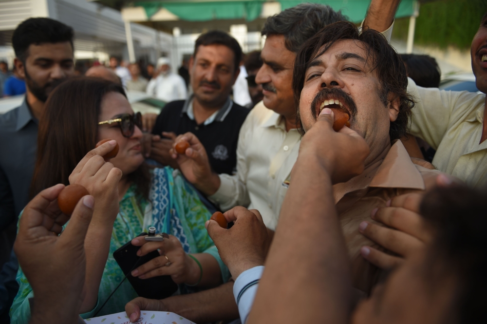 Imran Khan, center, chairman of Pakistan Tehreek-e-Insaf (PTI) political party speaks after he was elected as prime minister at the National Assembly in Islamabad on Friday. — Reuters